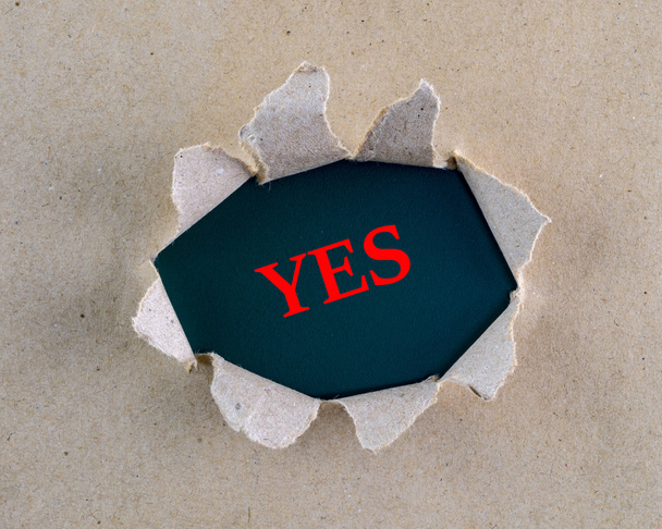 Carta ruvida marrone strappato con la parola "Sì" sulla superficie di sfondo
. - Foto, immagini