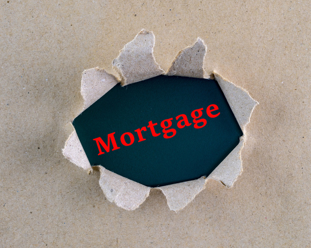 Arka plan yüzeyinde "Mortgage" kelime ile yırtık kahverengi kaba dokulu kağıt. - Fotoğraf, Görsel