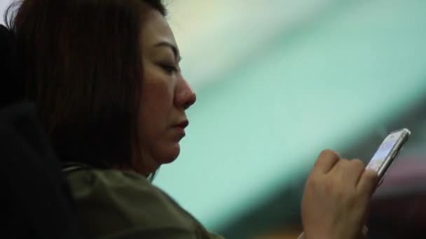 Азіатський жінка, торкаючись свій мобільний телефон, протягом дня, їздити в автобусі - Кадри, відео