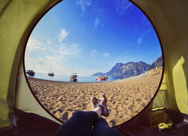 Donna felice seduta in una tenda, vista sulle montagne, cielo e mare.Olympos Beach. Cirali, Turchia
 - Foto, immagini