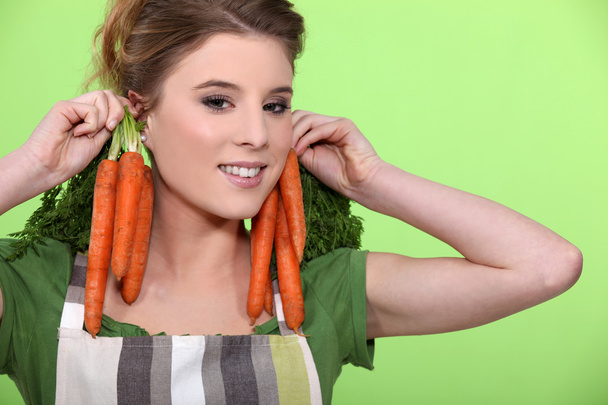 Woman with bunches of carrots - Φωτογραφία, εικόνα