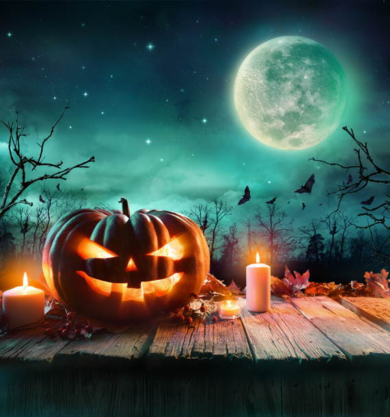 Halloween-Kürbis auf Holzplanke mit Kerzen in einer gruseligen Nacht - Foto, Bild