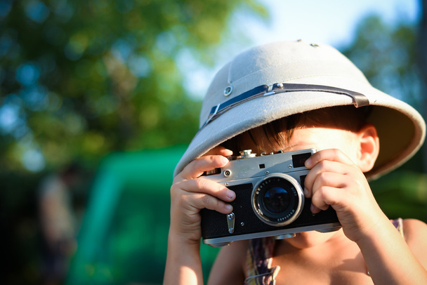 Kid taking photos using retro rangefinder camera - Fotó, kép