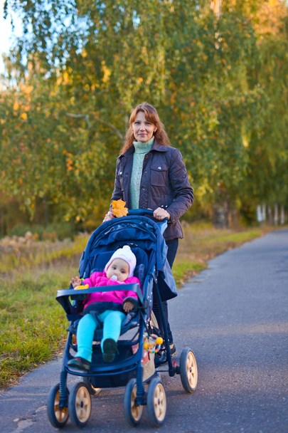 woman with little girl in stroller - Photo, Image