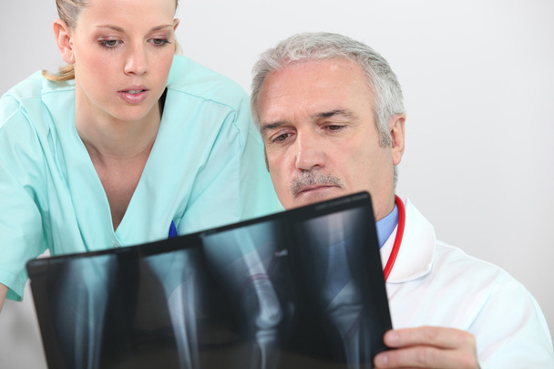 Médecin et infirmière regardant une radiographie de jambe
 - Photo, image