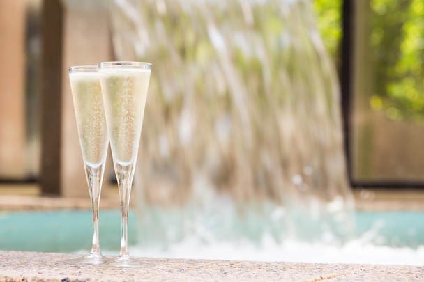 Дві склянки шампанського біля відкритого джакузі
 - Фото, зображення