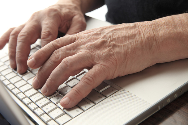 Senior typing on computer - Photo, Image
