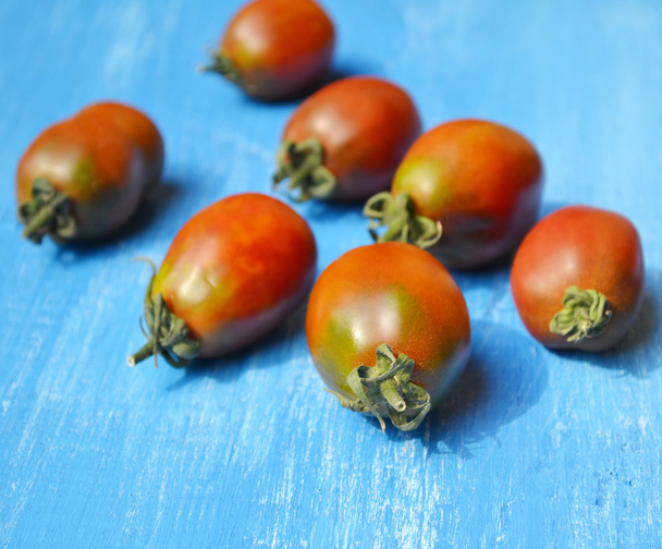 große dunkelrote Tomaten auf hellblauem Hintergrund - Foto, Bild