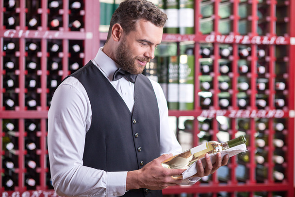 Attractive young male sommelier is working in cellar - Photo, image