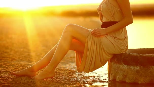 Jovem sentada em um pneu de carro grandes pernas curvilíneas de uma mulher andando pela praia de areia do deserto ao pôr do sol sexy deserto amarelo
 - Filmagem, Vídeo