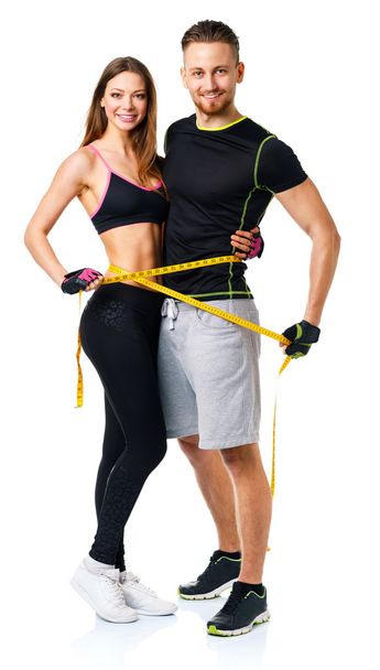 Happy athletic couple - man and woman with measuring tape on the - Photo, Image