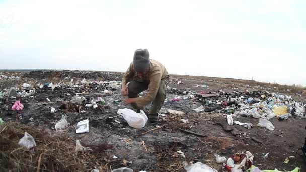 Vypsat nezaměstnaných bezdomovců špinavé vypadající muž potravinářské odpady na skládky sociální video - Záběry, video