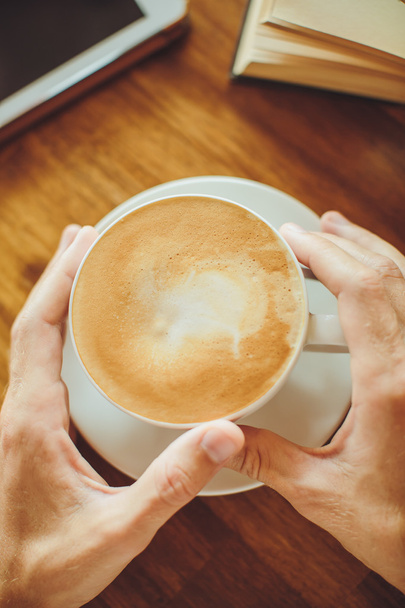 Men's hands hold  coffee and book on the table - Photo, Image