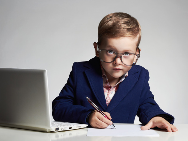 Young businessman using a laptop. Funny child in glasses - Foto, immagini