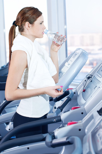 Young woman at the gym exercising. Drink - Фото, зображення