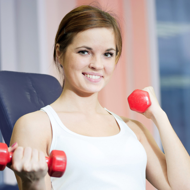 Beautiful sport woman doing exercise with dumbbell weight - Fotó, kép