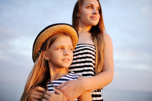 dvě dívky v pruhovaných šatech při západu slunce - Fotografie, Obrázek
