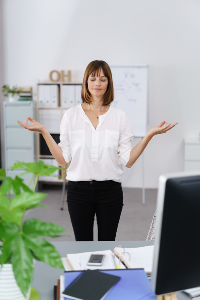 Businesswoman standing meditating - Фото, изображение
