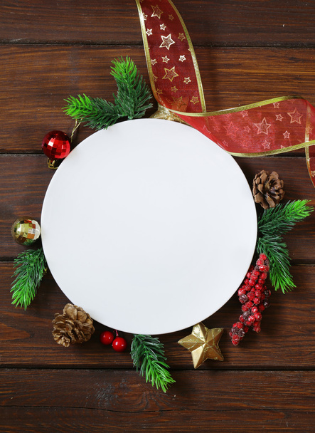 Christmas wooden background with fir branches, decoration and white plate - Φωτογραφία, εικόνα