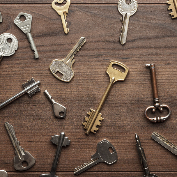 many different keys on wooden table - 写真・画像