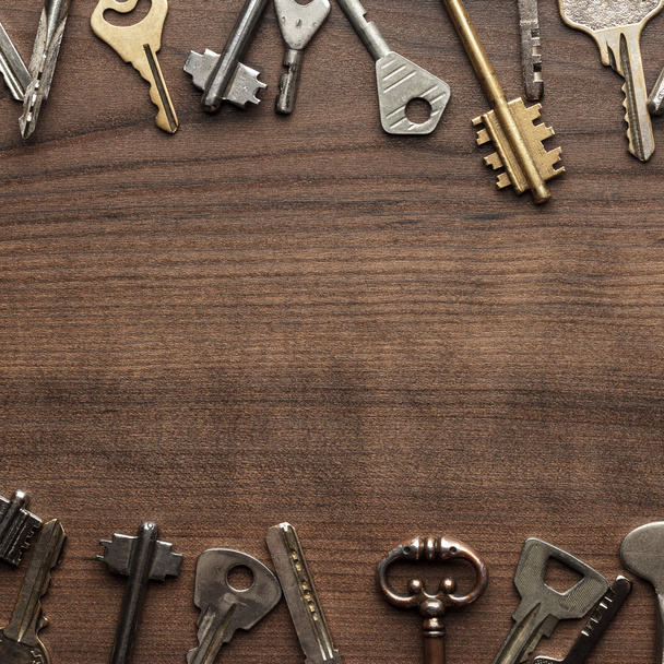 many different keys on wooden table - Φωτογραφία, εικόνα
