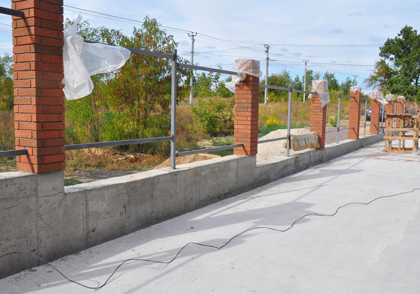 Building a Metal and Concrete, Bricks Fence with Iron Bar  Framework - Photo, Image