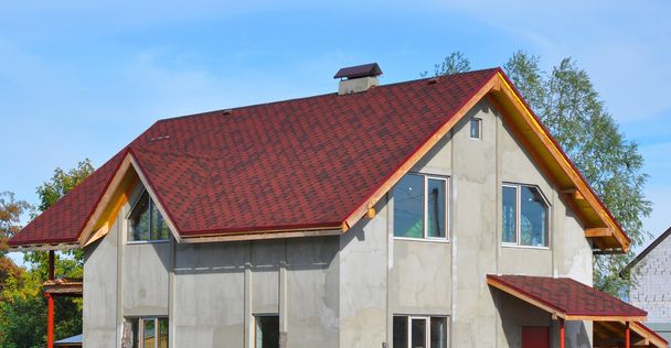 Uusi talo katto peitetty Bitumin laatat. Asfaltti vyöruusu katto
 - Valokuva, kuva