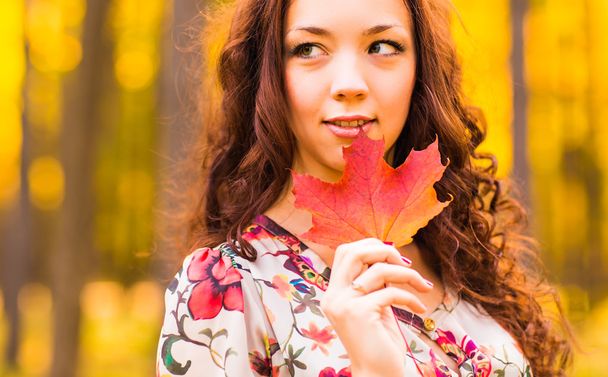 junge Frau mit Herbstlaub in der Hand - Foto, Bild