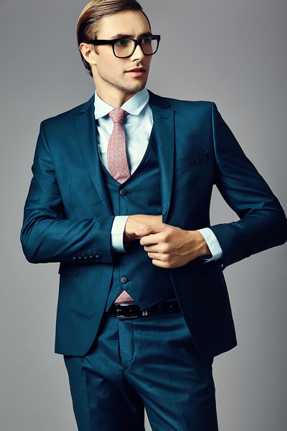 Young  elegant handsome  businessman male model in a suit and fashionable glasses, posing in studio - Foto, Bild