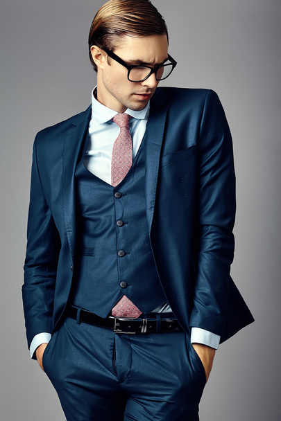 Young  elegant handsome  businessman male model in a suit and fashionable glasses, posing in studio - Фото, зображення