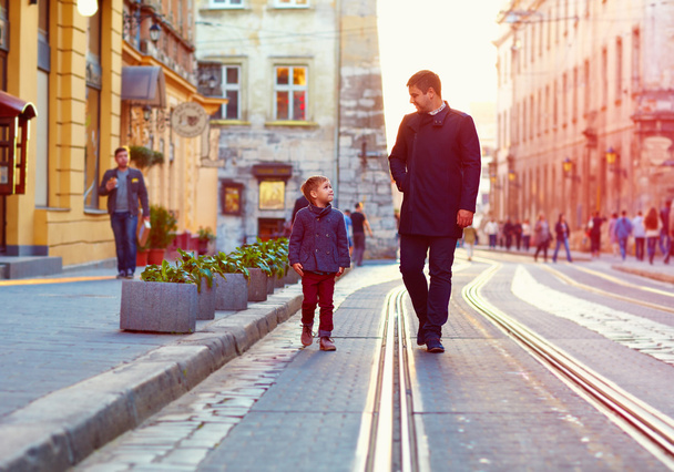 модний батько і син ходять по старій міській вулиці
 - Фото, зображення