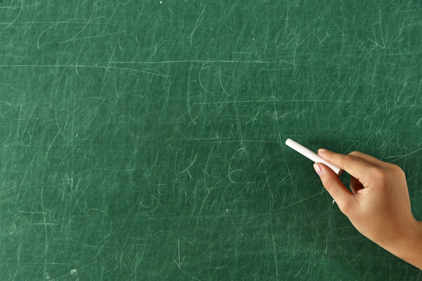 Female hand writing on blackboard with chalk, close up - Photo, Image