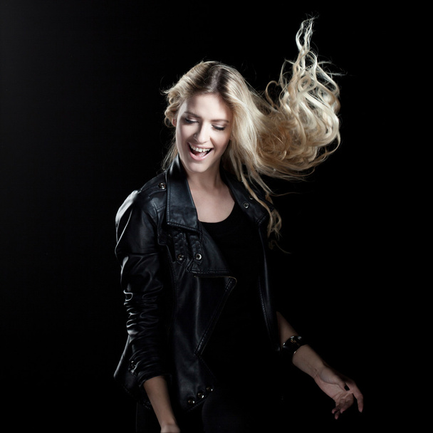 smiling young woman dancing, on a black background - Photo, Image