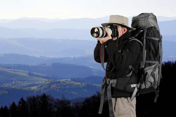 equipped traveler photographer takes pictures of nature - Photo, Image