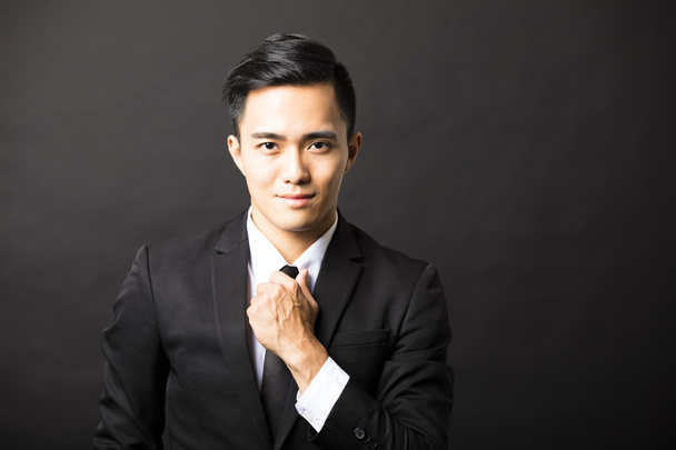 молодий азіатський бізнесмен на чорному фоні
 - Фото, зображення