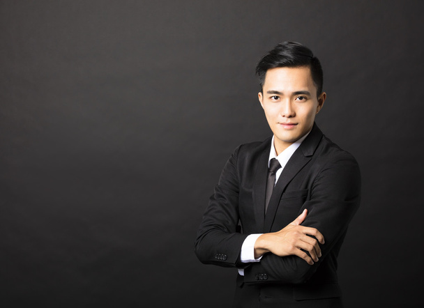 黒い背景にアジア系の若いビジネスマン - 写真・画像