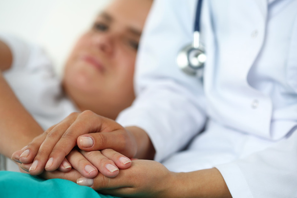 Φιλικό γυναίκα γιατρό χέρια κρατώντας το χέρι του ασθενούς - Φωτογραφία, εικόνα