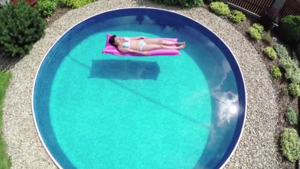 Жінка розслабляється в невеликому домашньому басейні
 - Кадри, відео