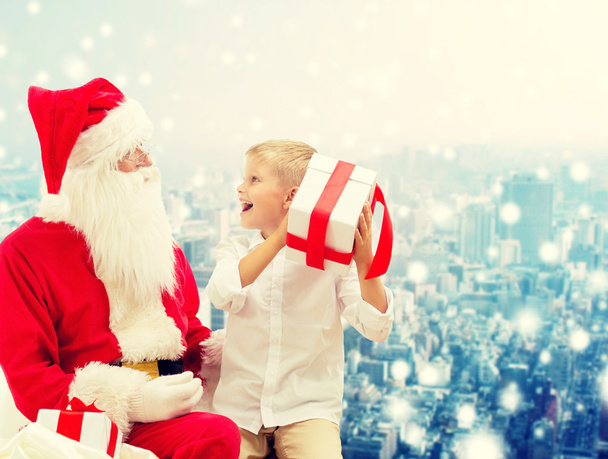 smiling little boy with santa claus and gifts - Photo, Image
