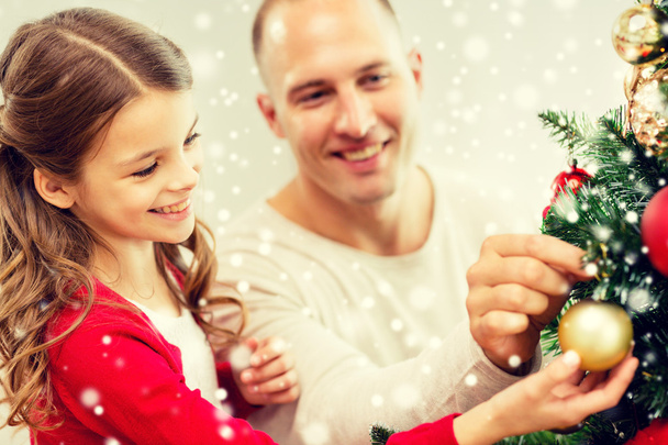 smiling family decorating christmas tree at home - Foto, Bild