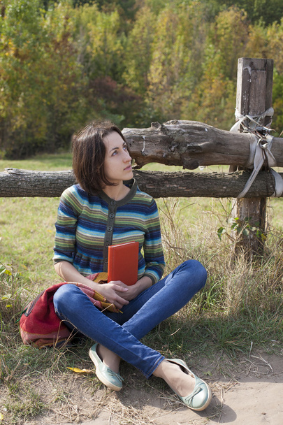 Девушка-путешественница сидит с книгой о природе
. - Фото, изображение