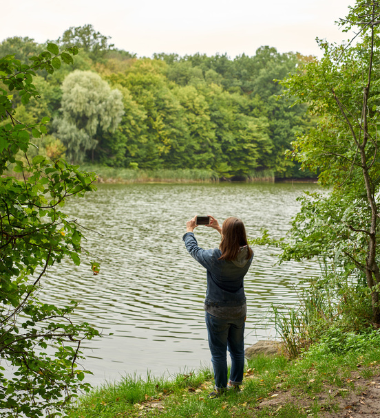mujer tomando fotos en la orilla del río
 - Foto, imagen