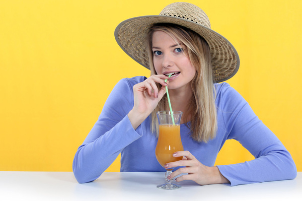 Woman drinking juice though a straw - Fotó, kép
