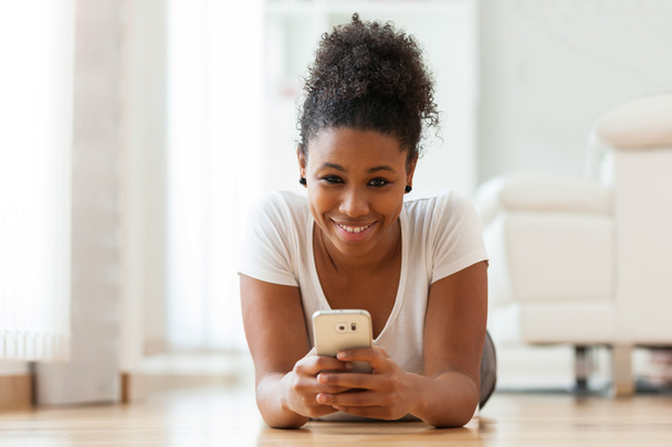 Mujer afroamericana enviando un mensaje de texto en un teléfono móvil
 - Foto, imagen