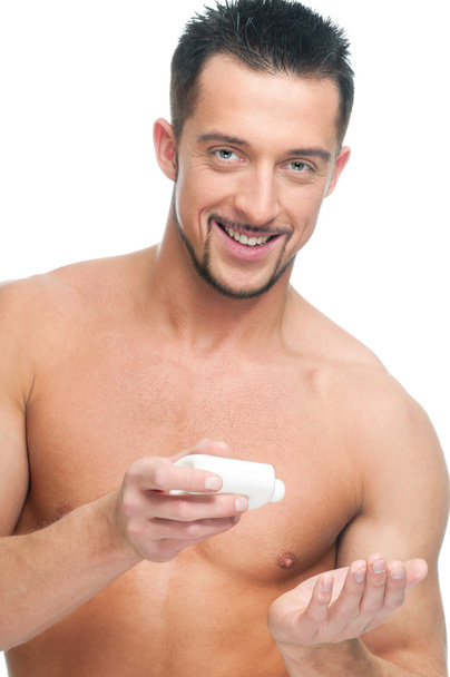 Young man applying cream. Cosmetic - Фото, изображение