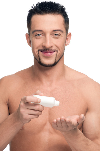 Young man applying cream. Cosmetic - Fotoğraf, Görsel