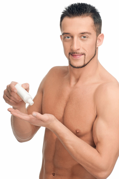 Young man applying cream. Cosmetic - Foto, Bild