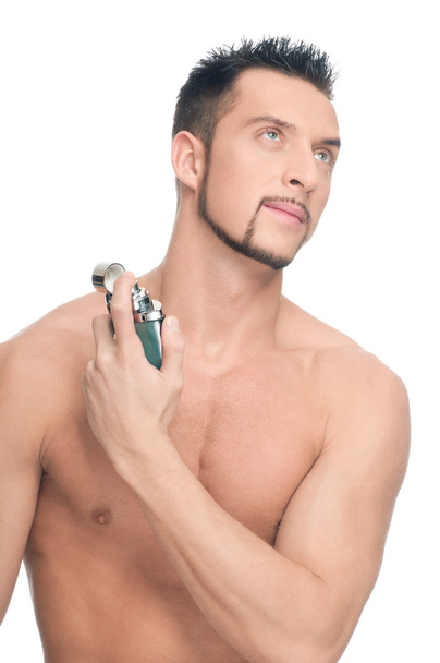 Young handsome man applying perfume - Foto, afbeelding