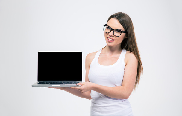 Smiling woman showing blank laptop screen - Foto, afbeelding