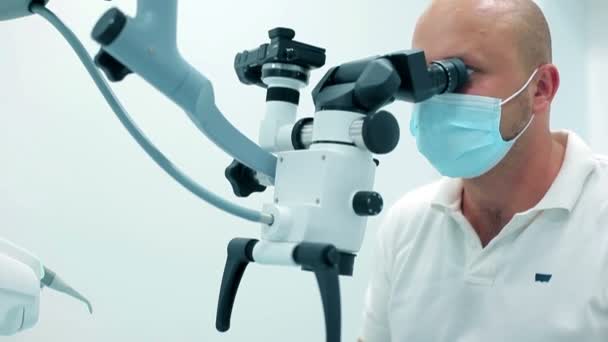 Dentist using a dental microscope - Кадри, відео